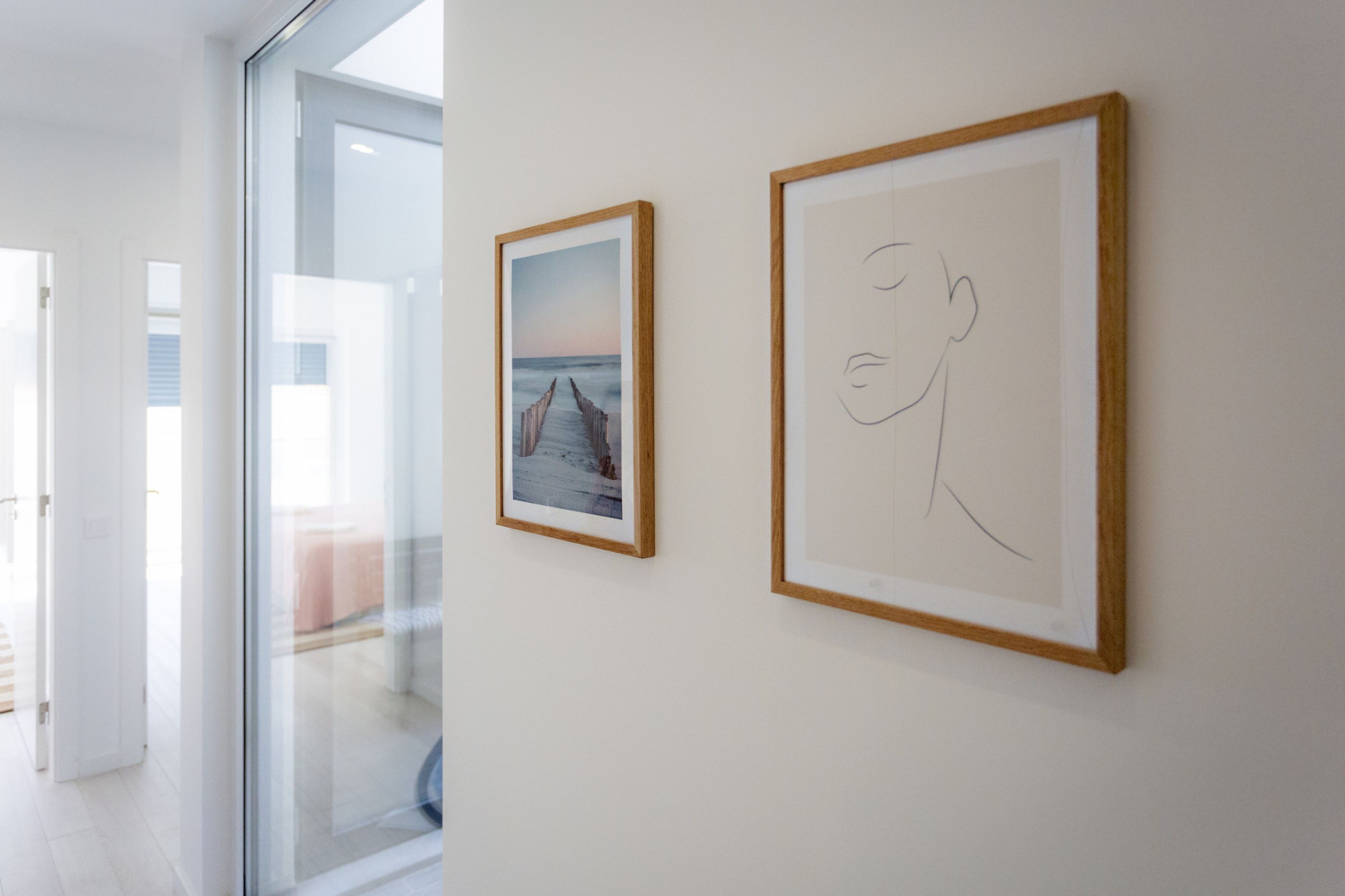 Two framed artworks on a wall in a modern interior space.
