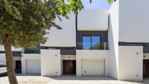 A modern building with a flat roof, large windows, and a paved driveway. - Special Cabanas in Tavira (Tavira)
