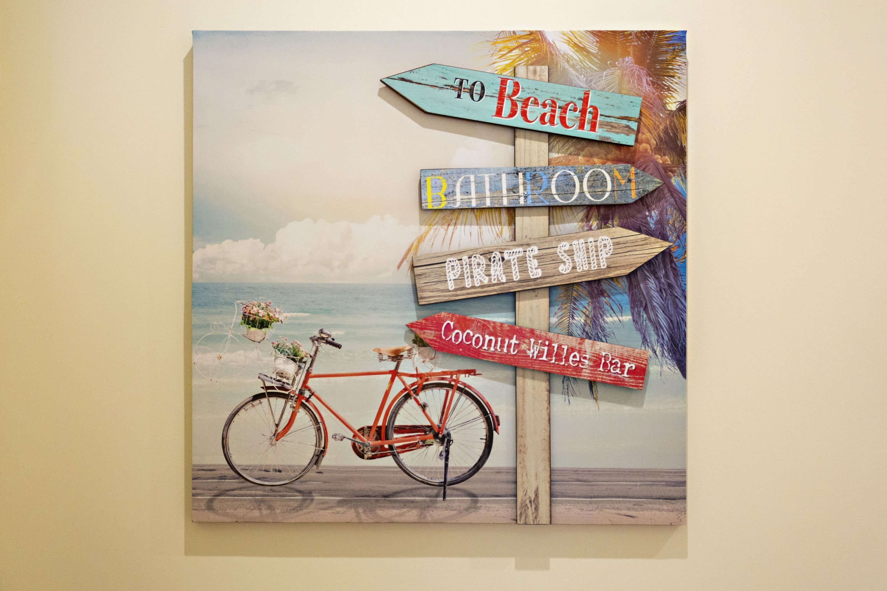 A beach-themed signpost with directions to 'Beach', 'Bar', 'Pirate Ship', and 'Coconut Wille Bar'.