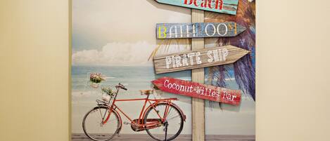 A beach-themed signpost with directions to 'Beach', 'Bar', 'Pirate Ship', and 'Coconut Wille Bar'.