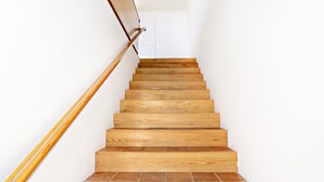 A wooden staircase with a handrail, leading to a white door at the top. - CV BC - Convento das Bernardas (Tavira)