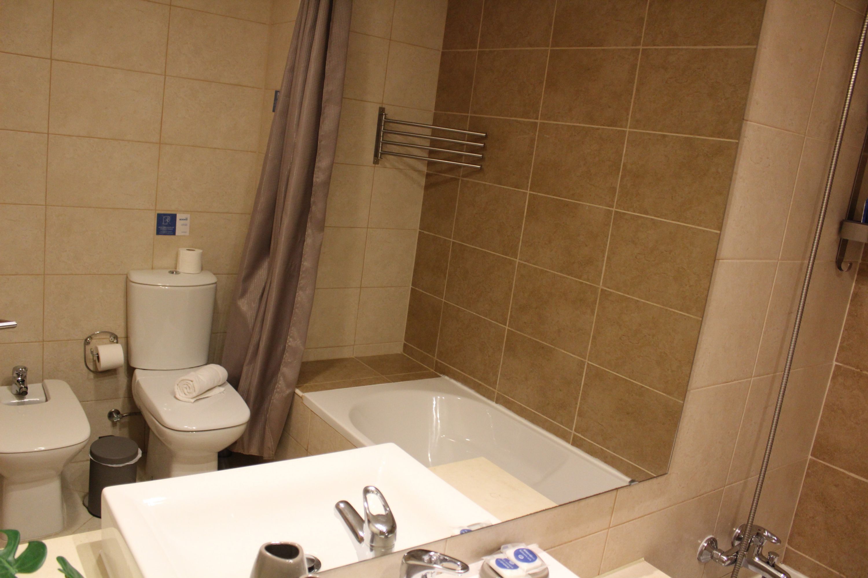 Een badkamer met toilet, wastafel en bad.
