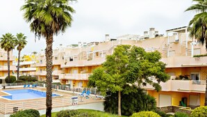 A hotel with multiple balconies, a swimming pool, and lush greenery. - Fleming Apartment in Tavira (Tavira)
