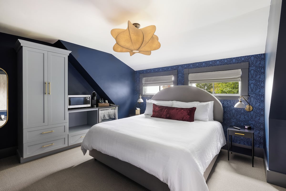 Une chambre à coucher avec un lit, une armoire, un bureau et une fenêtre.