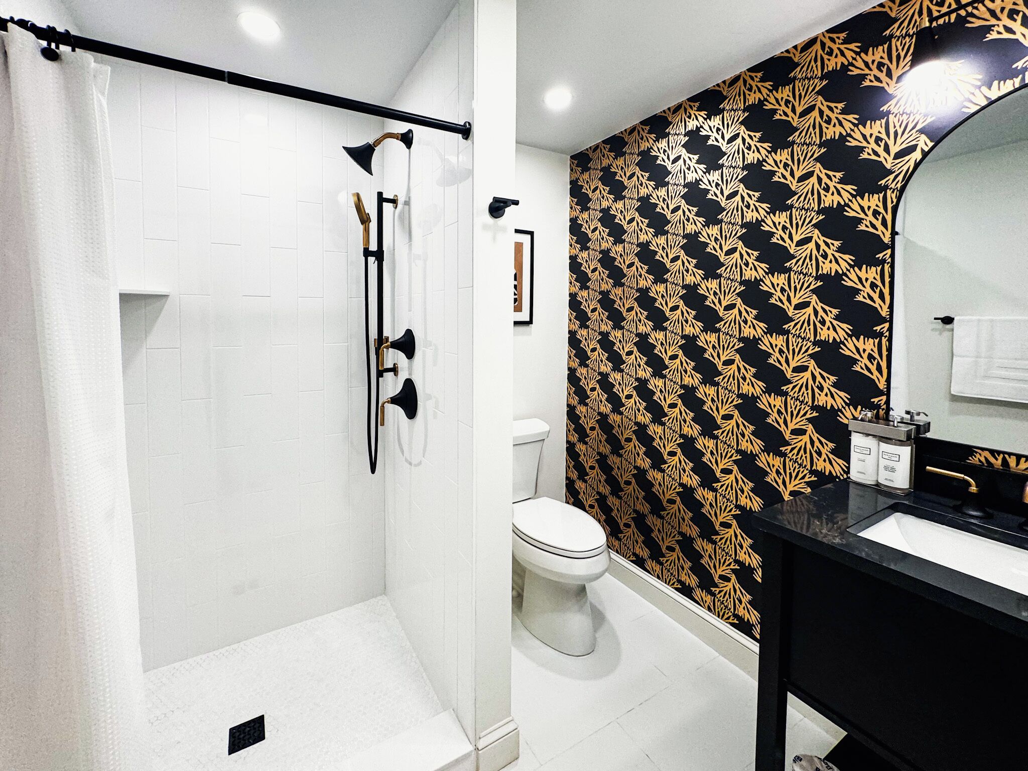A bathroom with a shower, toilet, and sink.