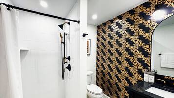 Ein Badezimmer mit Dusche, Toilette und Waschbecken.