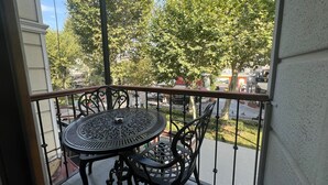 A balcony with a round table and chairs, overlooking a street with trees and buildings. - Demhat Hotel Old City (Istanbul)