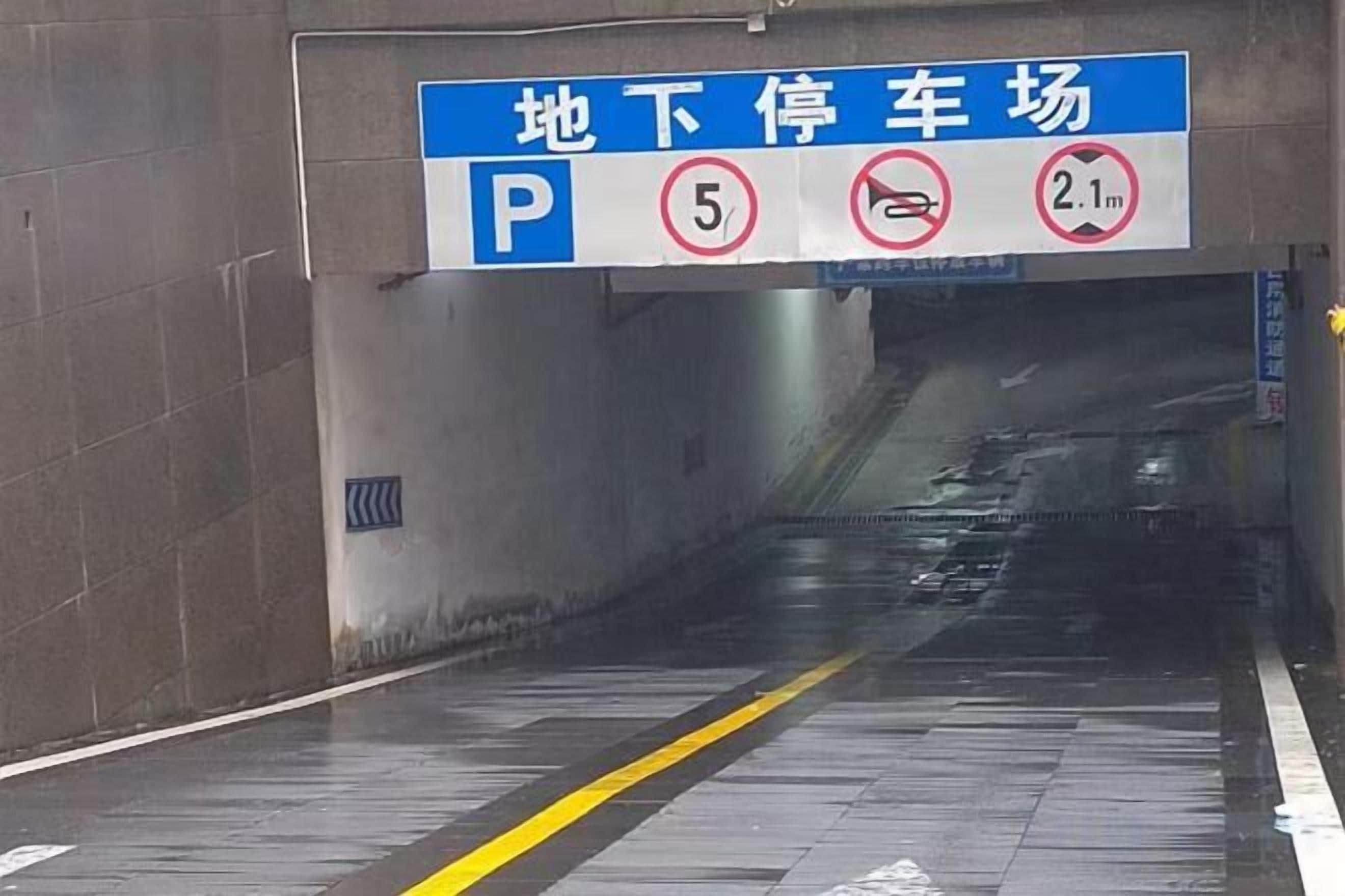 Señal de estacionamiento con símbolo de 'P', símbolo de prohibido estacionar y restricción de altura de 2.1 metros.