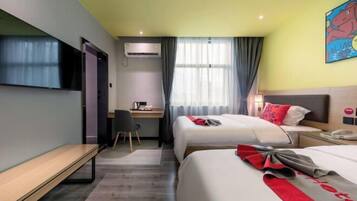 A hotel room with two beds, a desk, a TV, and a window with curtains.