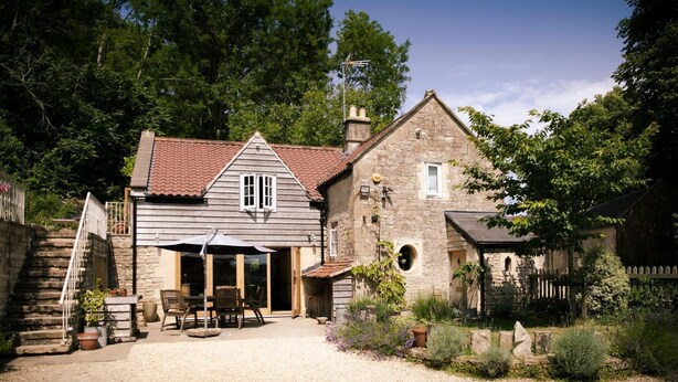 A rustic stone house with a red-tiled roof, a wooden porch, and a gravel driveway. - Cotswolds Aonb-near Bath-sleeps8 (Bath)