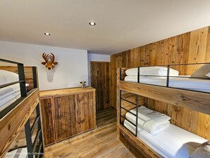A bunk bed room with wooden walls and a small cabinet. - Appartement  A-04  T4 (Font-Romeu-Odeillo-Via)