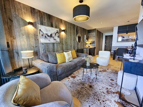 A modern living room with a grey sofa, a coffee table, and a cowhide rug. - Appartement B-03 T2 Cabine (Font-Romeu-Odeillo-Via)