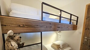 A bunk bed with a wooden headboard and a teddy bear on the lower bunk. - Appartement T2-Cabine B-02 - Collection Cassiopée (Font-Romeu-Odeillo-Via)