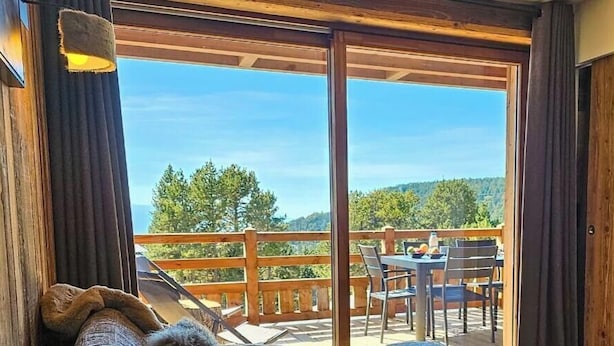 A wooden deck with a table and chairs, overlooking a forested landscape. - Appartement T2-Cabine B-02 - Collection Cassiopée (Font-Romeu-Odeillo-Via)