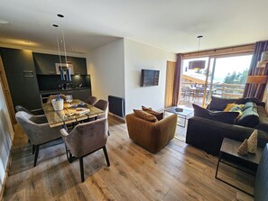 Uma sala de estar moderna com área de jantar, um sofá e uma mesa de centro.