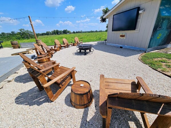 An outdoor seating area with wooden chairs and a fire pit. - Riverbend Hideaway - 5 Min to Downtown & Tubing (San Marcos)