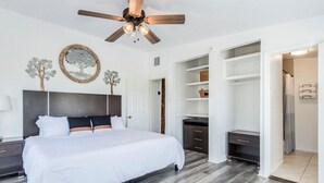 A modern bedroom with a large bed, a ceiling fan, and built-in storage. - Riverbend Hideaway - 5 Min to Downtown & Tubing (San Marcos)