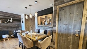 Un comedor con una mesa de madera, sillas e iluminación colgante.