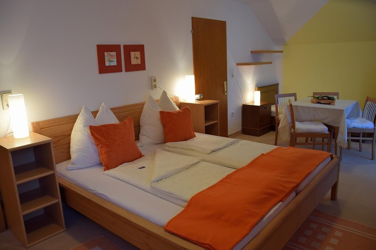 Une chambre à coucher comprenant un lit, des tables de chevet, un bureau et une chaise.