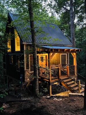 A rustic cabin with a wooden deck, a staircase, and a metal roof, surrounded by trees. - “The Shack” on Farmers Creek. Tree house  Tiny house (Boonville)