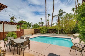 Relax by the pool surrounded by lush greenery and comfortable seating options.