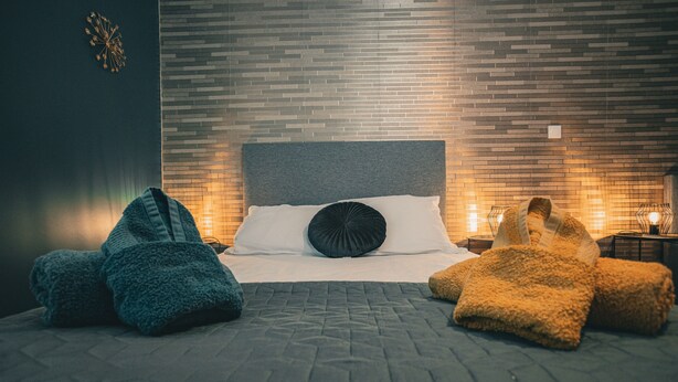 A neatly made bed with a quilted bedspread, two pillows, and two folded blankets. - Maison de Campagne 4 Avec Terrain de Pétanque, Idéal Pour les Familles et Amis (Vireux-Wallerand)
