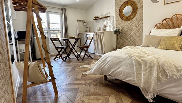 A bedroom with a bed, wooden floor, and a loft bed with a ladder. - Cocon Cosy & Chaleureux à Pézenas: Chez Roméo (Pézenas)