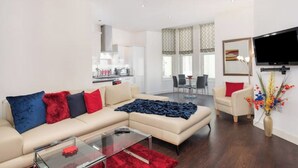 Una sala de estar moderna con un sofá, una mesa de centro y un televisor montado en la pared.