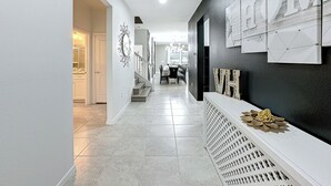 Ein Flur mit einer Treppe, die zu einem Essbereich führt.