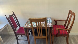 A dining area with a table and four wooden chairs, each with a different cushion.
