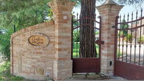 Un mur de briques sur lequel est apposée une enseigne indiquant « Casolare della Quiete », et une porte en métal portant le numéro « 13 ».