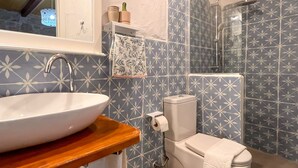 A bathroom with a white sink, toilet, and shower. - Eskikent Alaçatı (Cesme)