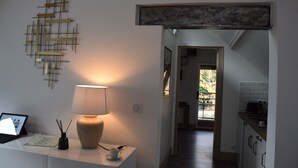 A modern kitchen with white cabinets, a countertop, and a view into the dining area. - "Le Rooftop de la fontaine", in a quiet, green setting (Luisant)