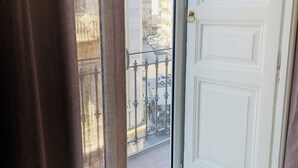 A view from a balcony with a white door and a curtain partially drawn. - Nerisa Home (Napoli)