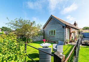 Escape to a serene garden retreat with a charming cottage and outdoor space.