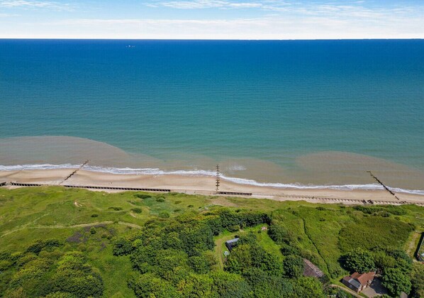 Enjoy a serene beachfront setting surrounded by lush greenery.