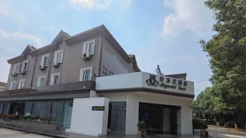 Un edificio de dos pisos con fachada moderna, un letrero que indica restaurante y una entrada protegida por una reja.