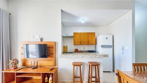 Una cocina moderna con armarios de madera, estufa empotrada y refrigerador blanco.