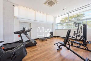 Ein Fitnessraum mit Laufband, Gewichtbank und verschiedenen Trainingsgeräten.
