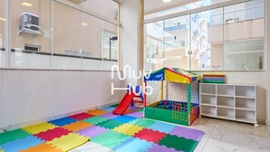 A play area with a slide and a ball pit, surrounded by colorful foam mats.