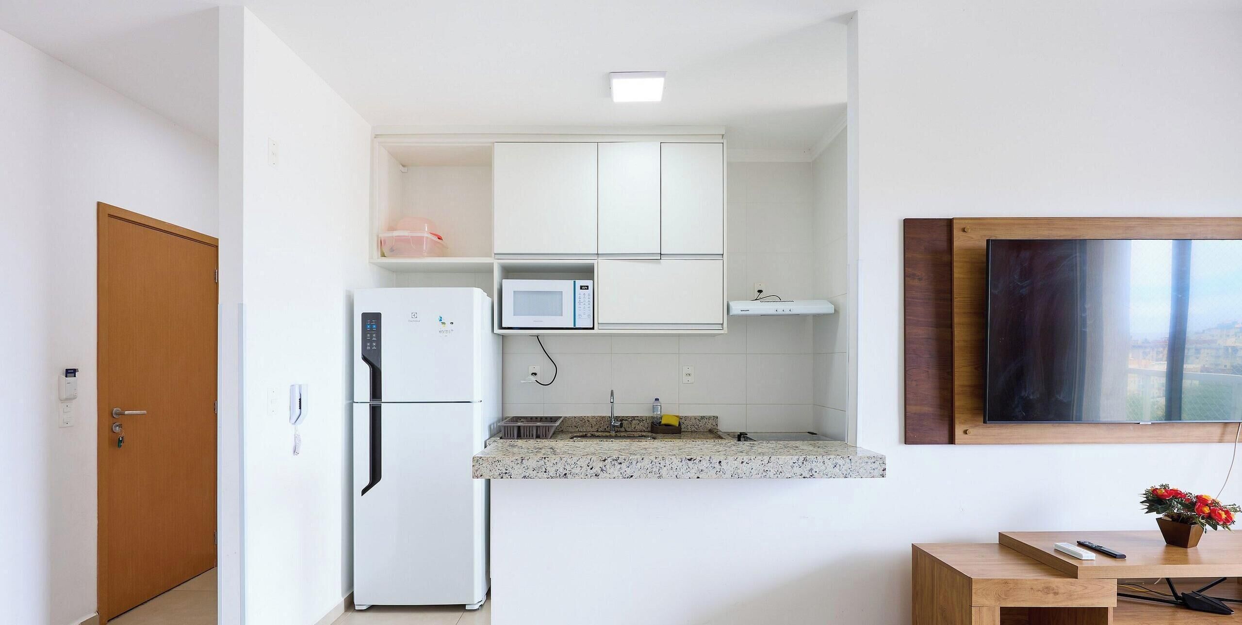 A compact kitchen with a refrigerator, microwave, and a small countertop.