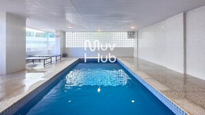 An indoor swimming pool with tiled walls and a bench area. - New apartment with air conditioning - REF JS45H (Ubatuba)
