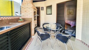 A patio area with a brick oven, outdoor seating, and a view of the interior. - Penthouse with Private Pool - REF 0150 (Ubatuba)