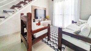 A modern bedroom with a bed, a desk, a chair, a TV, and a staircase. - Penthouse with Private Pool - REF 0150 (Ubatuba)