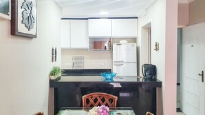 A compact kitchen with white cabinets, a built-in oven, and a coffee machine. - Penthouse with Private Pool - REF 0150 (Ubatuba)