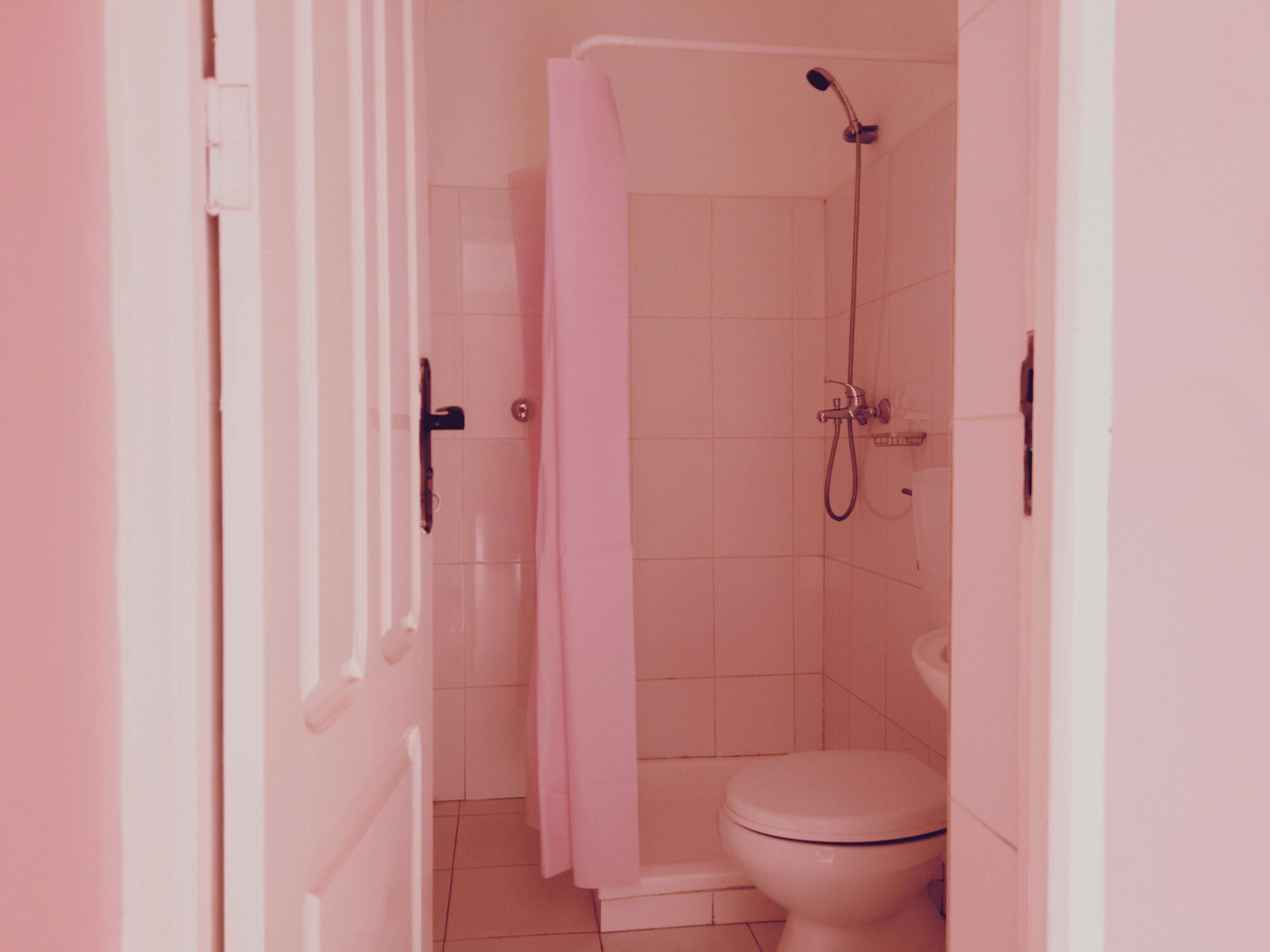 Un baño con ducha, inodoro y una puerta.