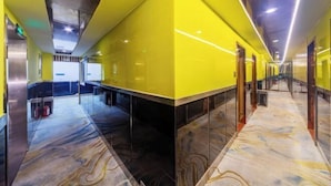 A corridor with a yellow accent wall, marble flooring, and glass doors leading to rooms. - Changsheng Hotel (Nanjing)