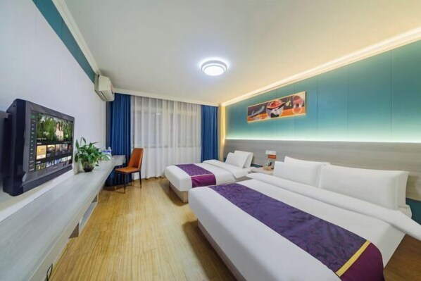 A hotel room with two beds, a desk with a computer, a chair, and a window with curtains. - Changsheng Hotel (Nanjing)