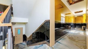A modern hotel interior with a marble floor, a staircase, and a glass elevator. - Changsheng Hotel (Nanjing)