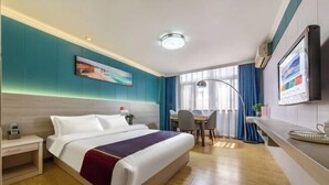 A hotel room with a large bed, a desk, and a chair. - Changsheng Hotel (Nanjing)